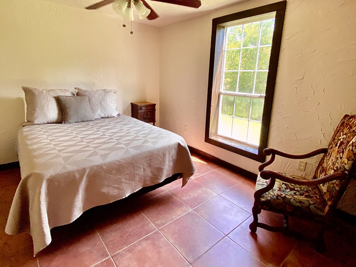 bedroom with queen bed next to window
